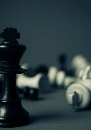 A chess king standing while other pieces lie fallen, representing strategic litigation
